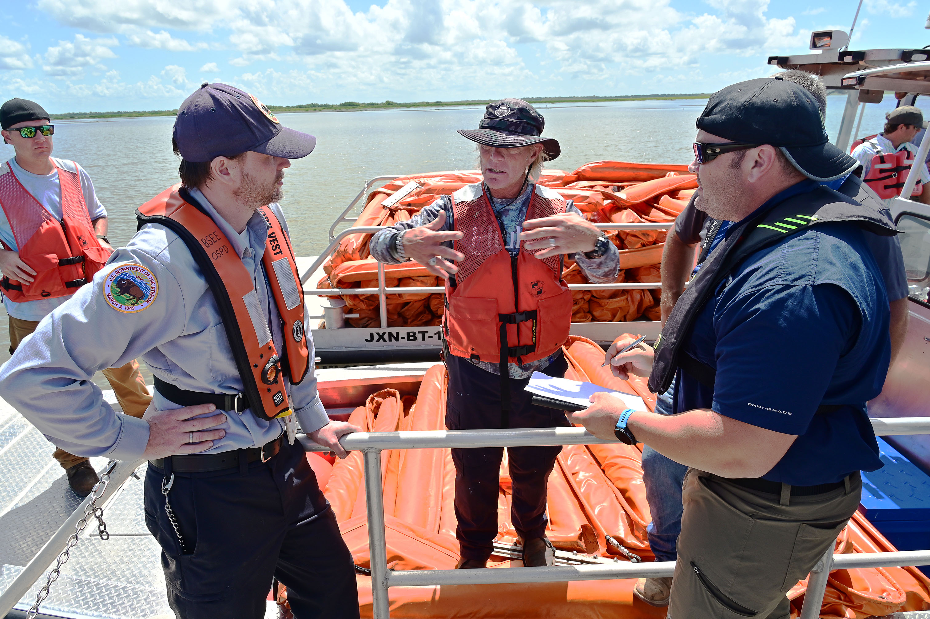 John Calvin, a senior preparedness analyst in the Bureau of Safety and Environmental Enforcement’s Gulf Regional Office of Safety and Preparedness Division, discusses containment boom deployment strategies with a member of E3 Environmental and Equinor during a boom deployment exercise Wednesday, June 1, 2022, off the Louisiana coast. The boom deployment was the physical verification of Equinor’s response strategy in case of an actual emergency as part of a government initiated unannounced exercise conducted by BSEE.