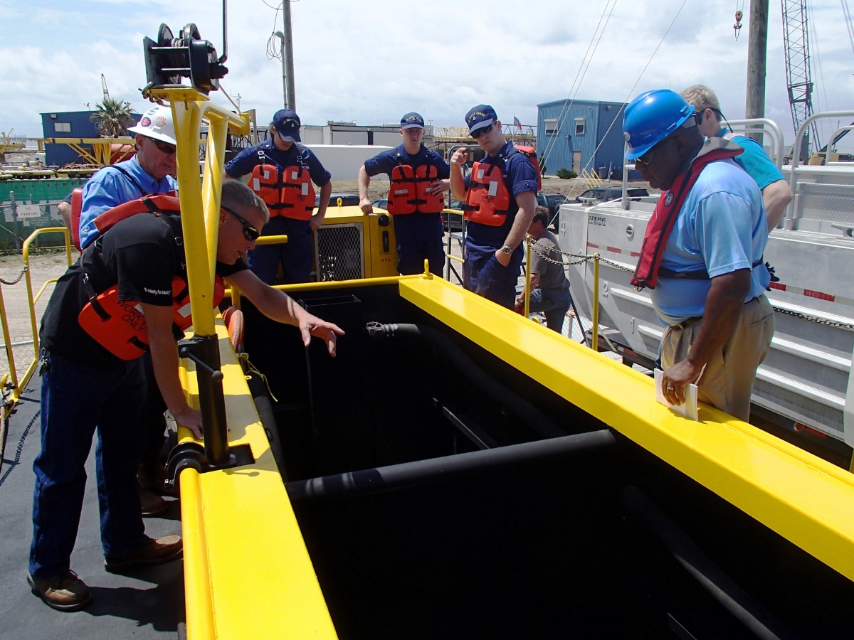 An industry representative explains his oil spill  response equipment to a BSEE Senior Preparedness Analyst and U.S. Coast Guard personnel  during a joint BSEE-USCG inspection in the Gulf of Mexico.