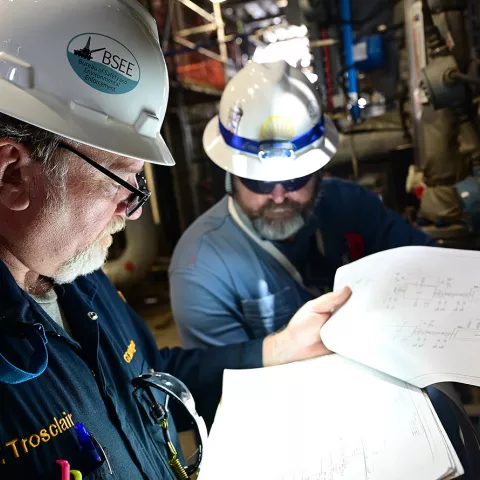 Troy Trosclair (left), a senior operations advisor from the Bureau of Safety and Environmental Enforcement New Orleans Regional Office, reviews a schematic for Shell’s Vito platform May 10, 2022.